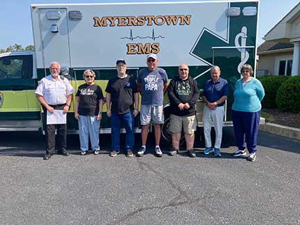 Photo of residents' committee posing in front of Myerstown EMS ambulance